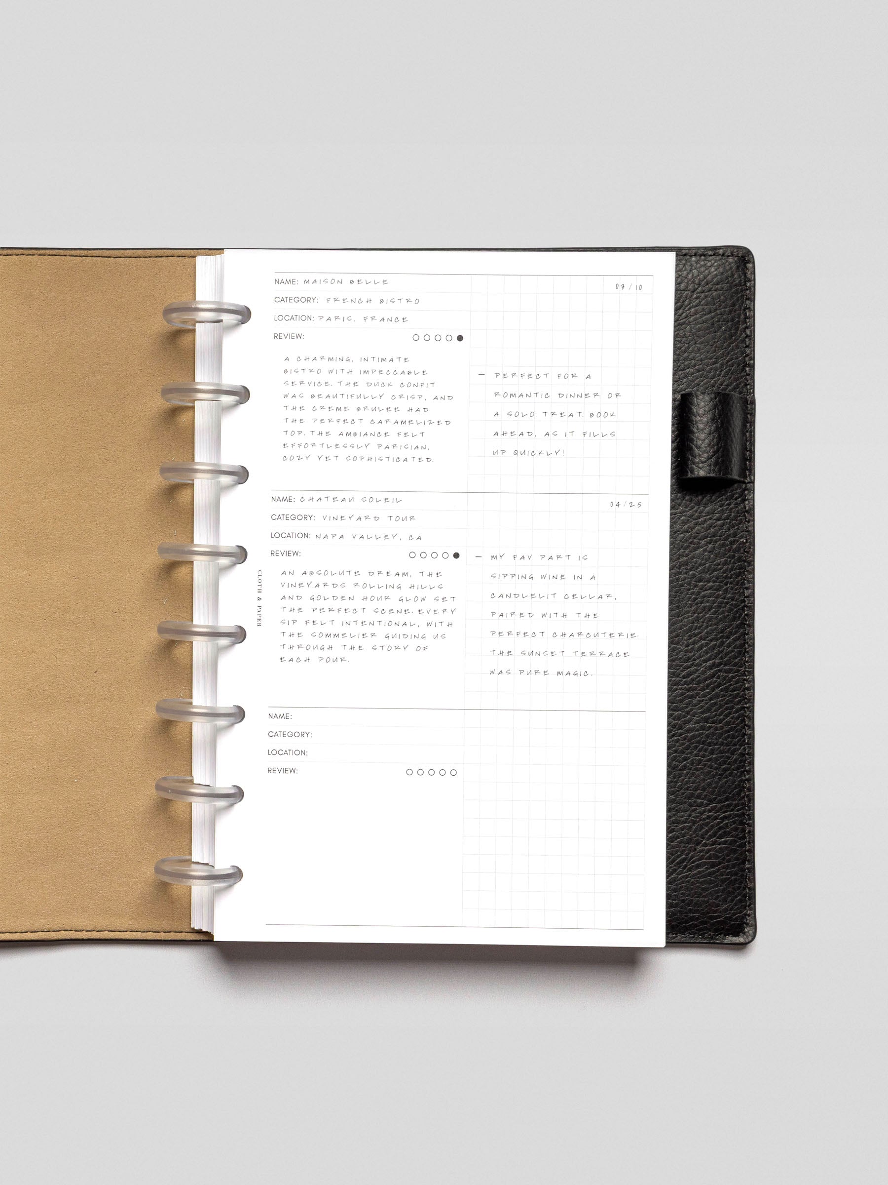 Experience Tracker Insert demo page in Half Letter size inside a planner, showing two logged entries, including a restaurant and a vineyard. A date is written in the corner, and the right grid columns include short reflections.