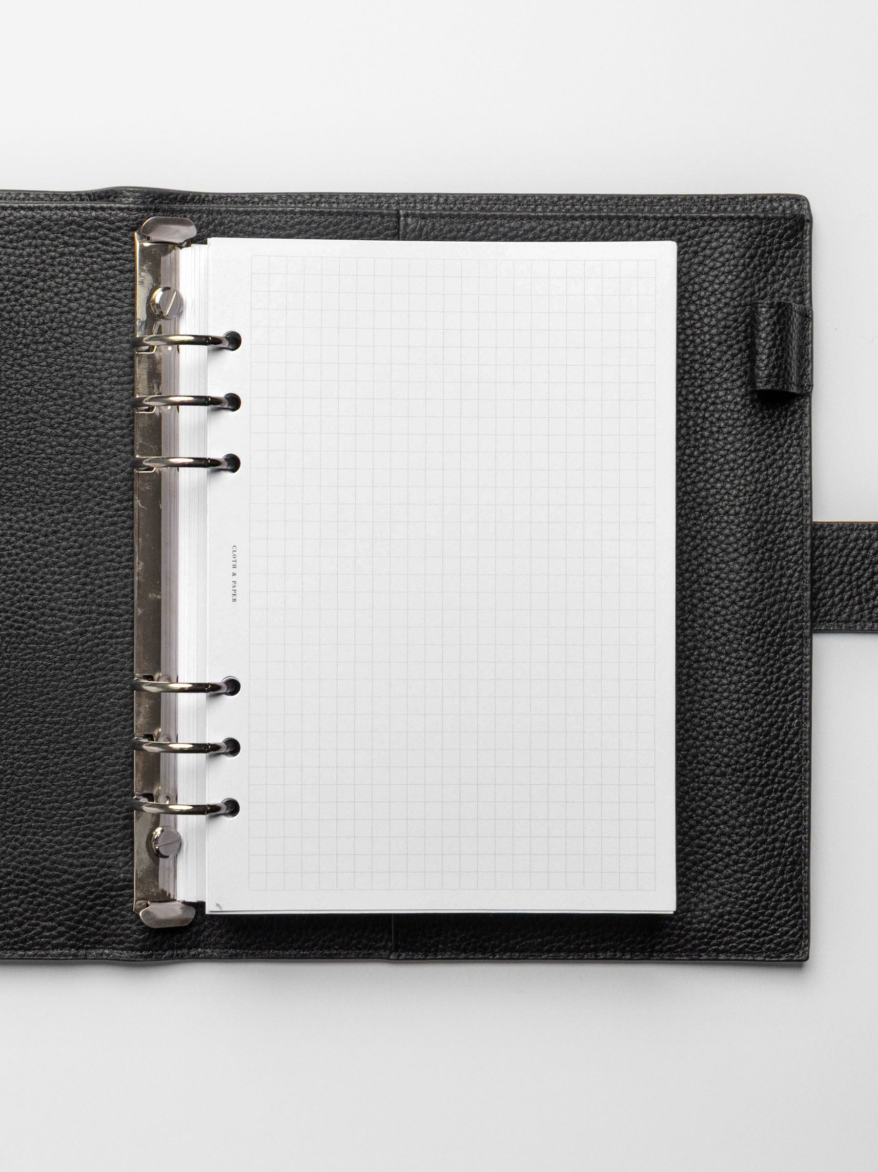 A5 planner with silver rings in a black leather agenda featuring graph note inserts.