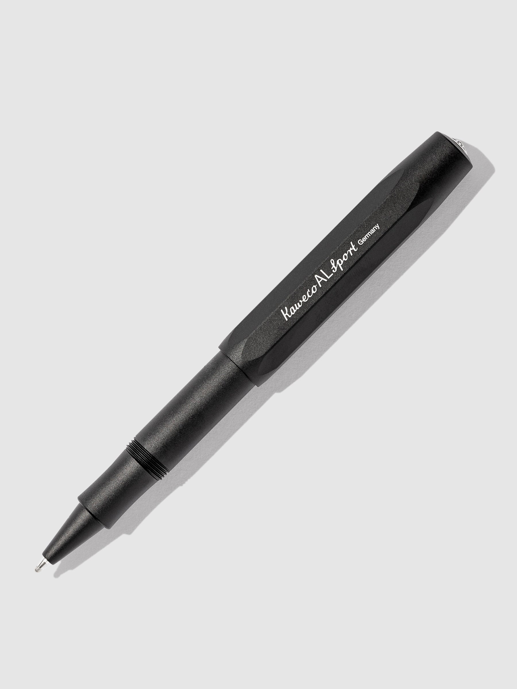 Kaweco AL Sport Rollerball Pen, Black, Cloth and Paper. Kaweco pen displayed on a neutral background. The pen's nib is exposed.