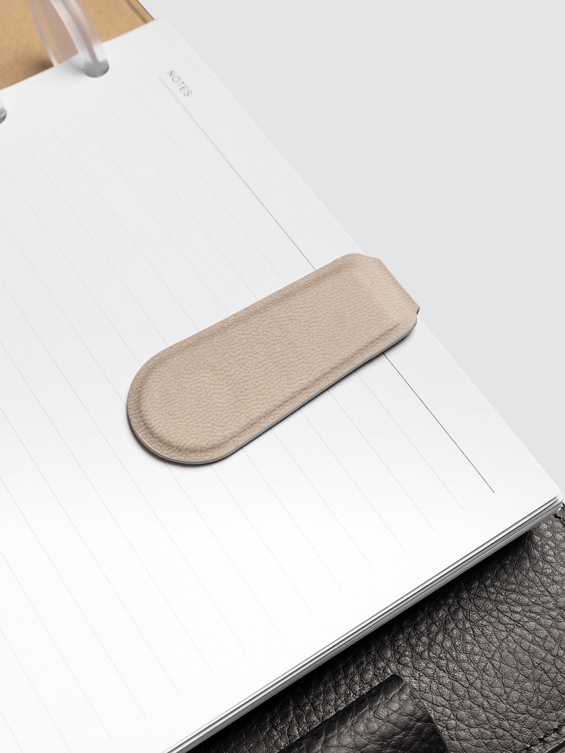 Magnetic Bookmark Smooth Leather in light taupe shown flat, top view, showing notched top edge and textured grain