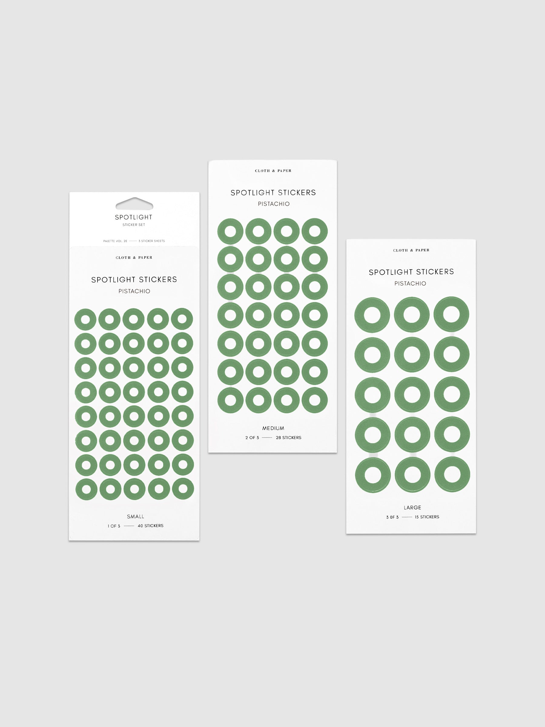 Three sheets of spotlight stickers in small, medium, and large sizing arranged together on a neutral background