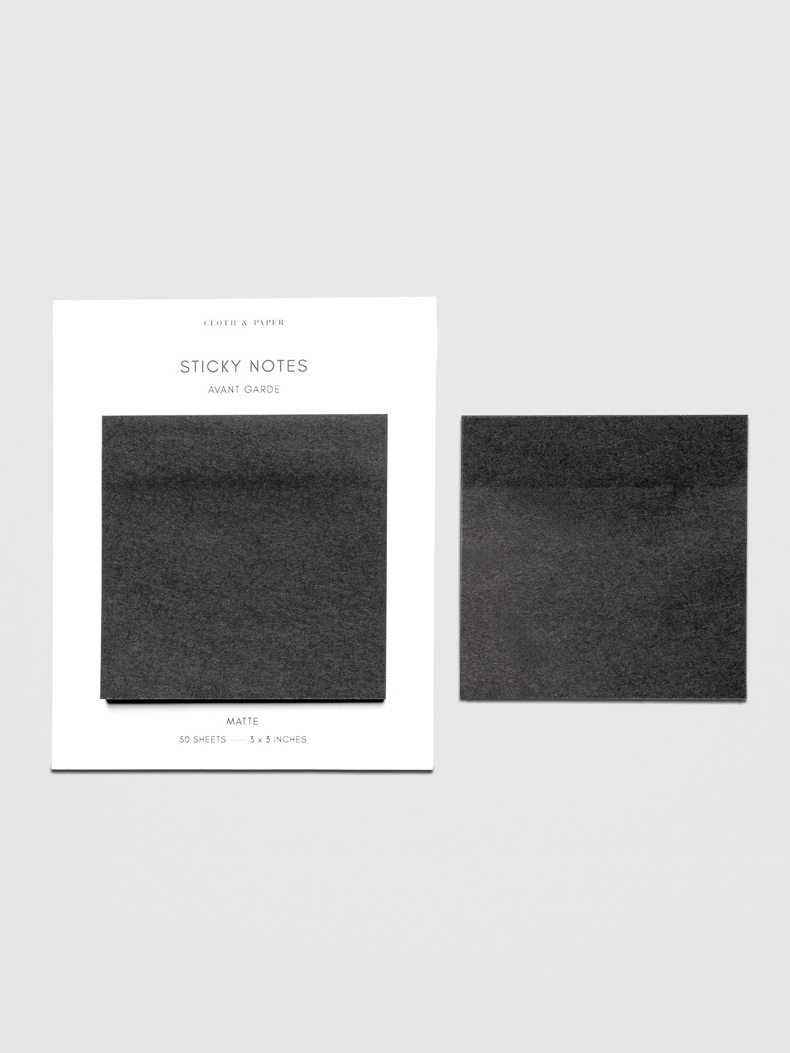 Avant Garde Sticky Notes, Cloth and Paper. Sticky notes with white ink gel pen resting on sticky note pad displaying writing sample.