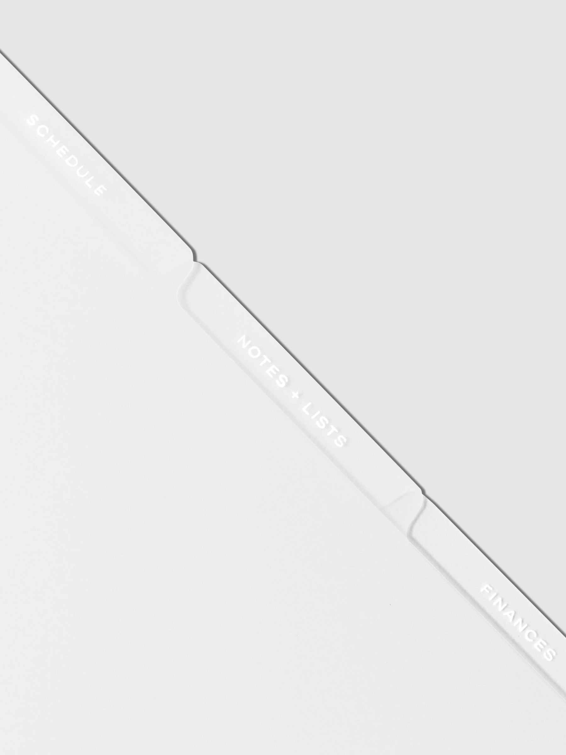 Closeup of white tab dividers displayed on a neutral background.
