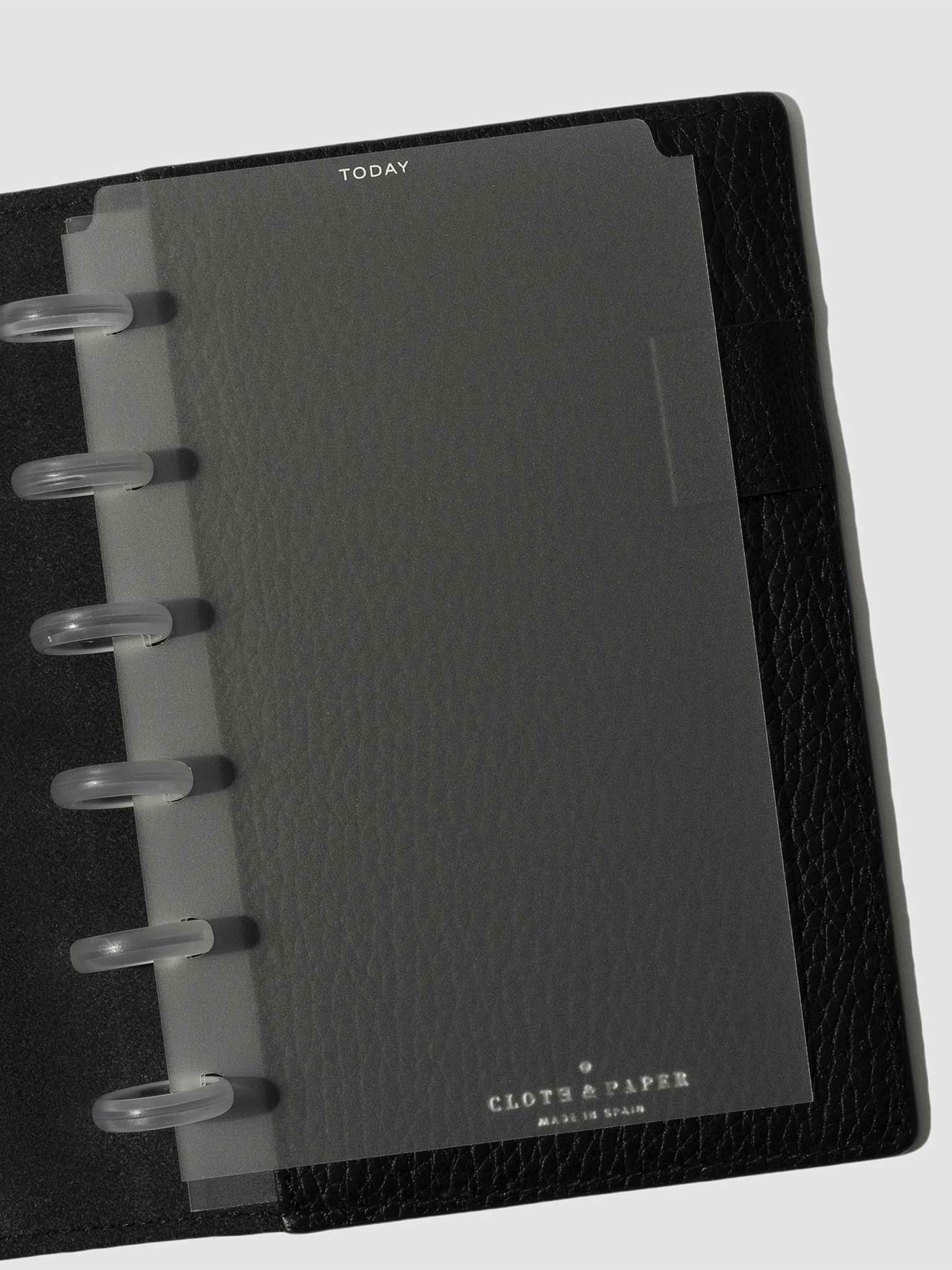White  foil divider displayed in a black leather planner.