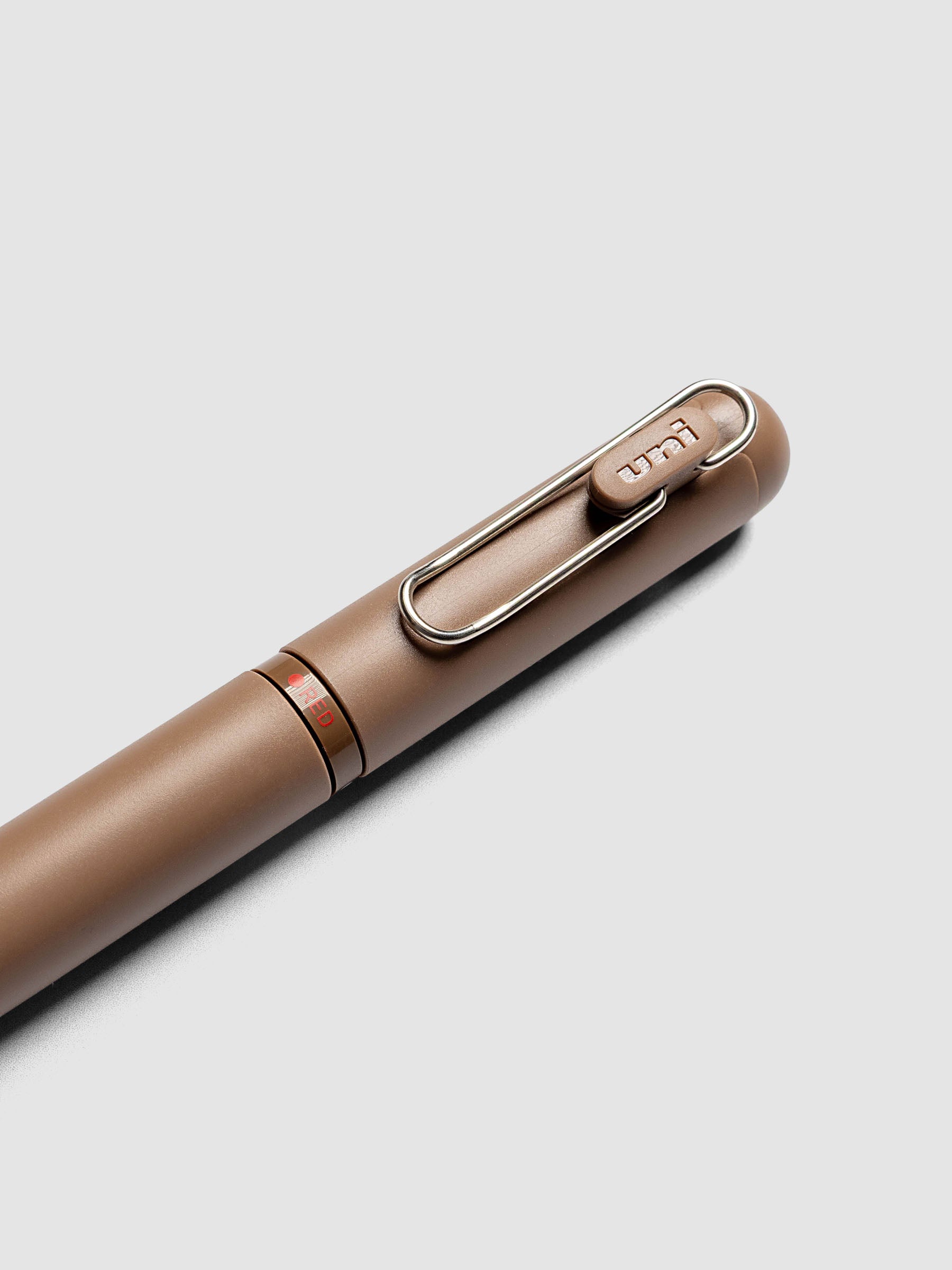Uni-ball One 3-Color Ballpoint Pen in brown close up of clip and RED color indicator