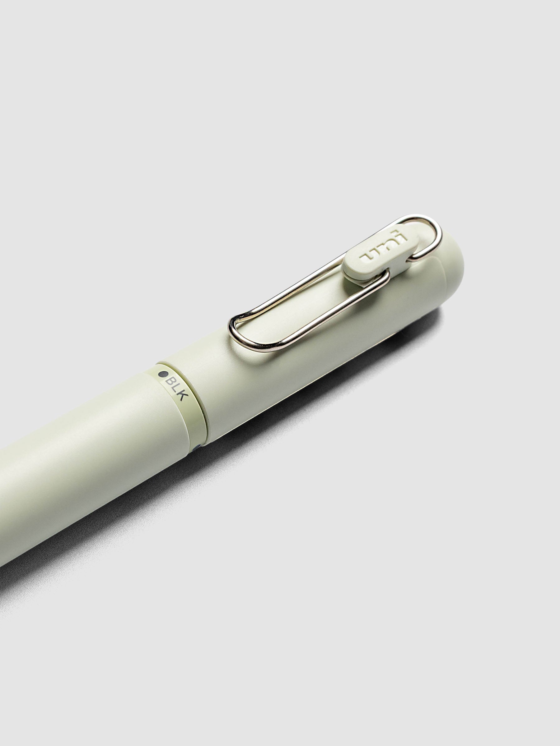 Uni-ball One 3-Color Ballpoint Pen in pale sage green close up of clip and BLK color indicator