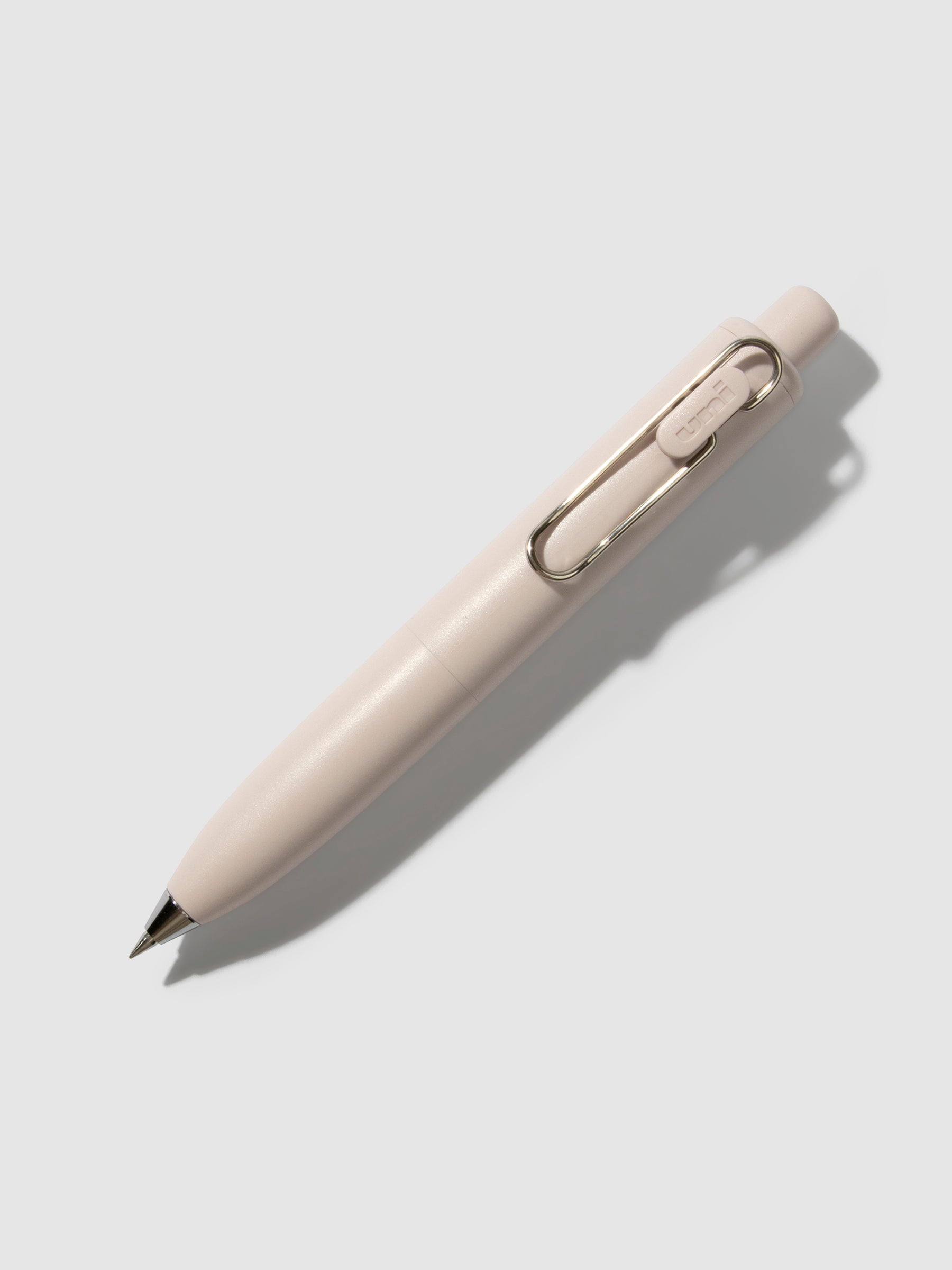 Uni-Ball One P Gel Pen, Cloth and Paper. Pen turned to the right on a neutral background. Color pictured is Peach.