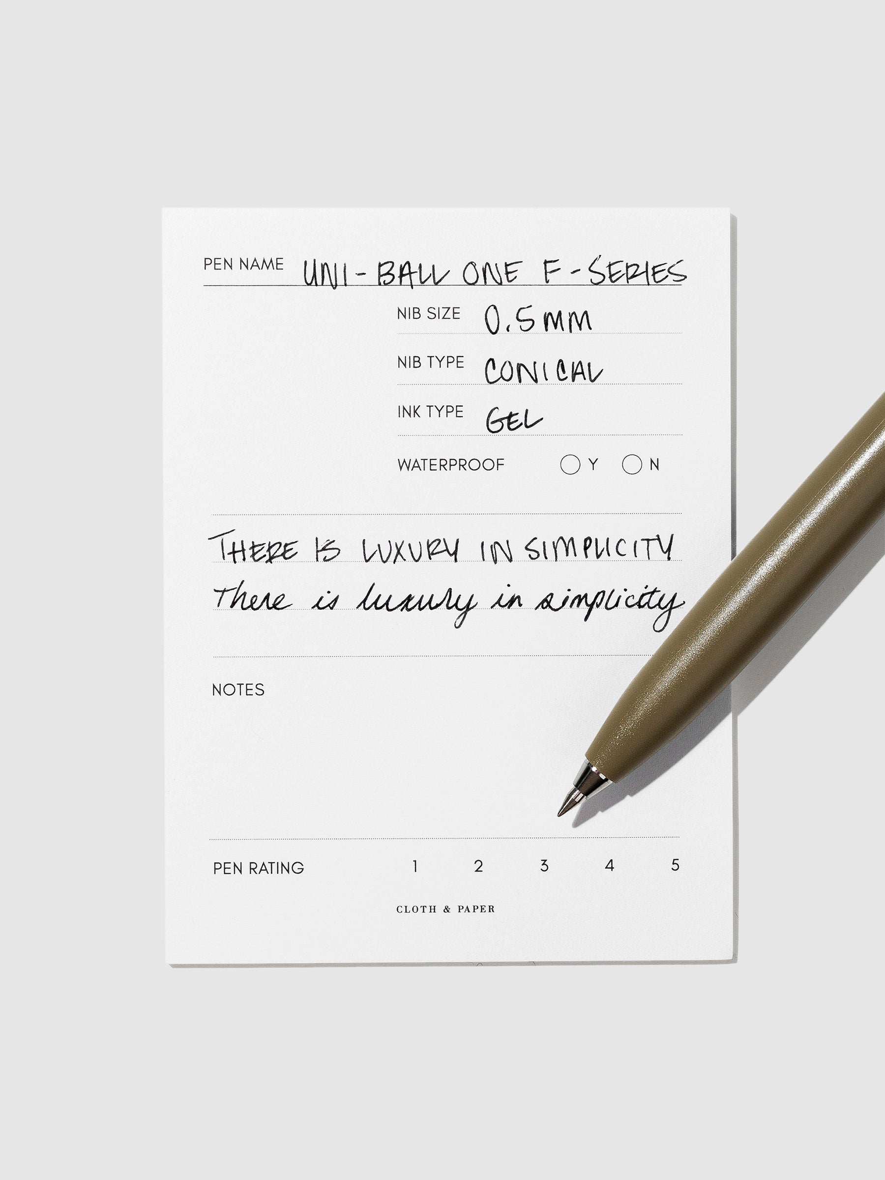 Olive pen resting on an in use pen test sheet.