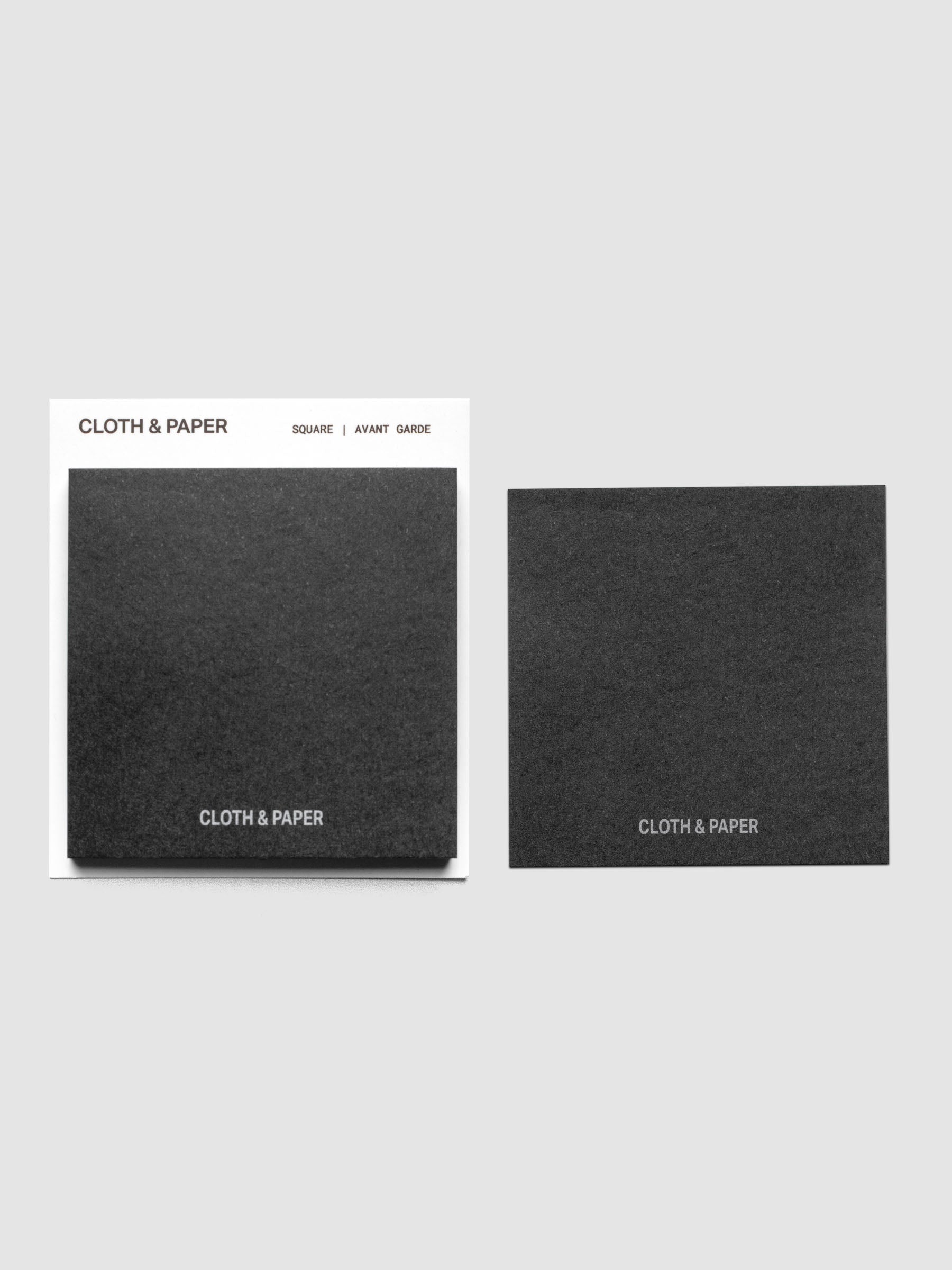 2" x 2" black matte paper Cloth & Paper Sticky Notes on a backing card and one on the background.